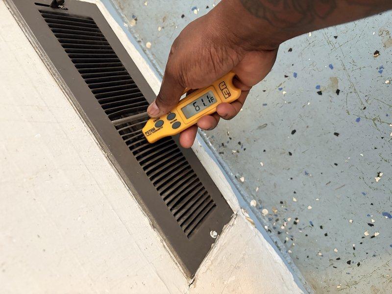 Completed HVAC maintenance inspection on residential heating and cooling system. Verified indoor air handler operation and measured supply air temperature at 61°F at the unit. Inspected outdoor condensing unit, confirmed fan motor operation, and verified condenser coil condition with protective grille intact and functional.