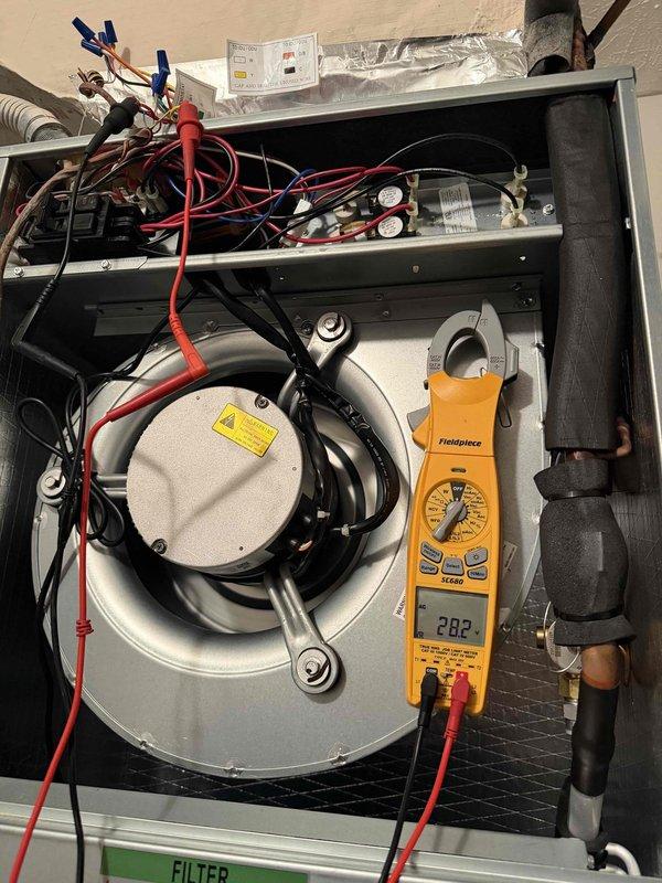 # No Cooling Complaint - Recent Installation

Responded to no cooling call on 4-month-old system. Upon arrival, confirmed unit would not operate when thermostat called for cooling. Removed access panel and performed diagnostic testing using digital multimeter. 

Testing revealed 28.2-volt reading at blower motor assembly, indicating low voltage issue preventing proper system operation. Inspected all wire connections at motor housing and control board, noting proper routing secured with mounting clips. Traced electrical circuit through system components to identify source of voltage drop.

Checked air filter condition and found standard residential filter in place with adequate airflow. Verified refrigerant line connections and pressure gauge assembly at service ports showed no signs of refrigerant loss or system leaks.

Corrected low voltage condition at motor circuit. Cycled system through complete startup sequence and verified proper operation of all components. Unit now cooling norm