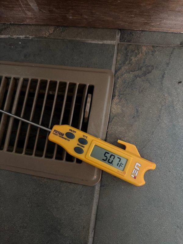 Completed comprehensive cooling system maintenance inspection on residential HVAC unit. Performed visual inspection of air handler interior components including refrigerant lines, condensate drain system, and insulation integrity, noting normal moisture accumulation on evaporator coil surfaces. Verified system airflow performance at supply register, measuring 50.7 CFM output temperature, confirming proper cooling delivery to conditioned space.