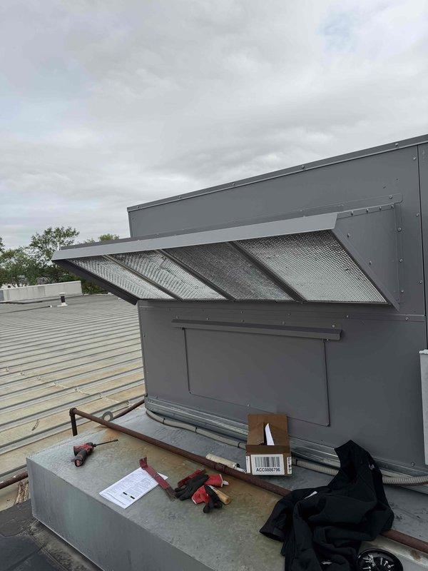 Completed installation of rooftop economizer unit on commercial HVAC system. Unit was properly mounted on rooftop platform with angled louver ventilation section secured and all fasteners tightened to manufacturer specifications. Installation was confirmed and system is operational.