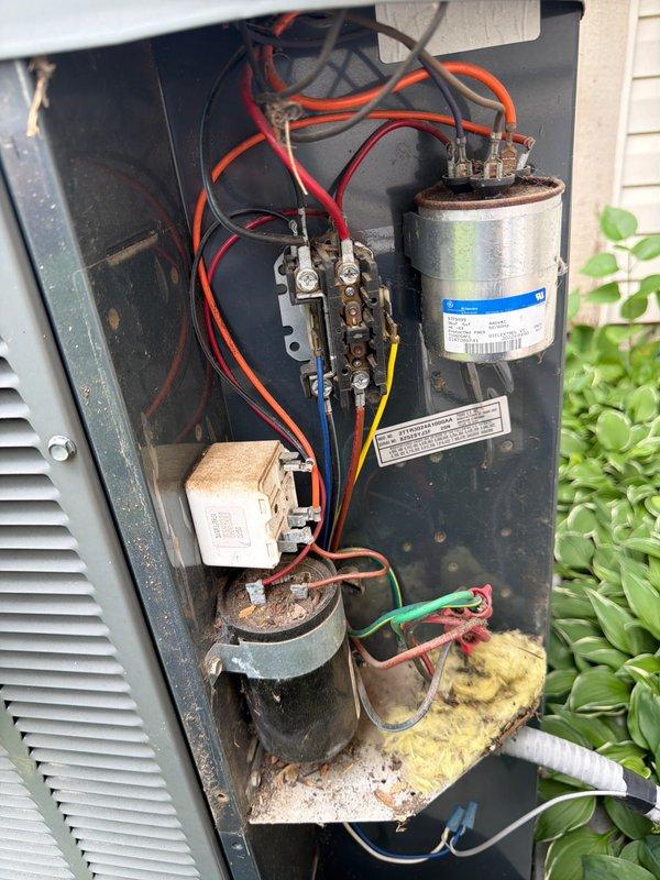 Completed comprehensive AC tune-up on outdoor condensing unit and indoor air handler system. Performed visual inspection of electrical components including capacitor, contactor, and relay connections; all wiring and terminals found to be secure with minor age-related weathering noted. Cleaned debris and insulation material from base of outdoor unit. Verified proper operation of compressor and associated electrical components. Inspected indoor Trane furnace and connected ductwork; confirmed all equipment labels and specifications are visible and intact. System tested and operating within normal parameters at time of service completion.
