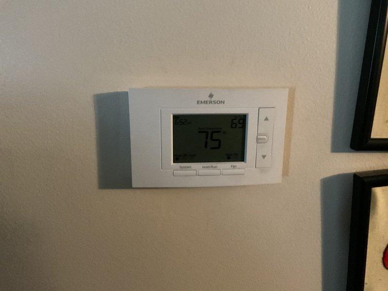 Completed full HVAC system installation including all equipment as specified in project documentation. Ran new low voltage 7-wire thermostat control wiring from mechanical equipment location through unfinished basement area to living space. Installed and programmed Emerson digital thermostat, verified proper communication with heating and cooling equipment, and confirmed system operation at 75 degrees with all functions responding correctly.