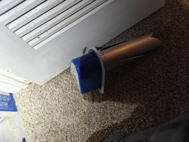 Replaced HALO air purification unit under warranty in residential HVAC system. Removed existing unit showing accumulated particulate matter on internal mesh filters and installed new cylindrical air purification device. Verified proper airflow at floor register using testing instrument to confirm system operation post-installation.