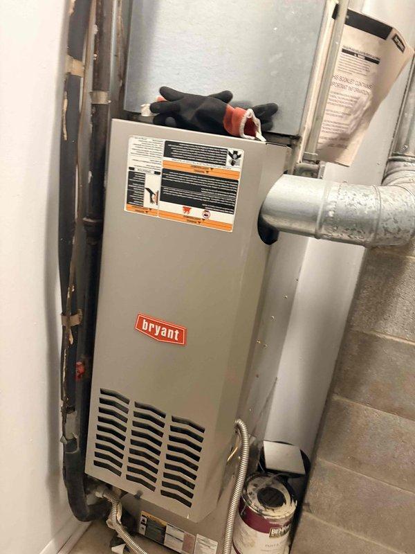 Responded to no heat call on 10+ year old Bryant furnace located in utility closet. Performed diagnostic inspection of unit, checked electrical connections, thermostat communication, and gas supply. Inspected heat exchanger, burner assembly, and blower motor operation. Documented current condition of equipment with photos showing unit installation, ductwork connections, and auxiliary components including condensate pump. Completed system evaluation and provided findings to property management for repair approval before proceeding with any necessary corrective work.