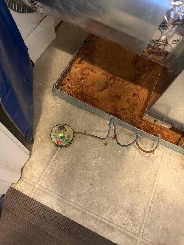 Responded to repeat service call for non-operational air conditioning system. Upon inspection, discovered significant condensate drainage issue with excessive rust-colored water accumulation in drip pan beneath air handler, indicating prolonged overflow condition and potential secondary drain line blockage. Cleared primary and secondary condensate drain lines, verified proper drainage flow, checked unit operation, and confirmed system cooling properly with no further drainage backup issues.