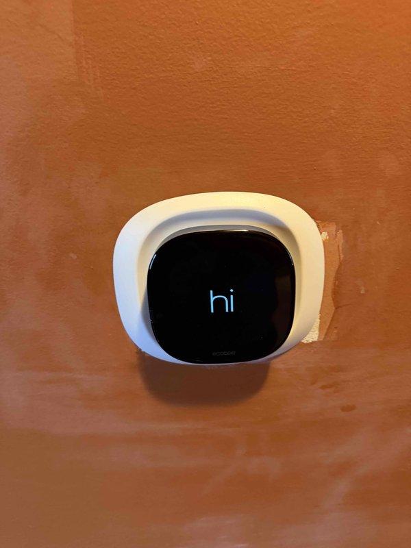 Replaced defective Ecobee smart thermostat under warranty coverage. Disconnected existing unit, transferred all low-voltage wiring connections to new thermostat base including power, heating, cooling, and common wire terminals, then mounted and powered up replacement unit which initialized successfully.