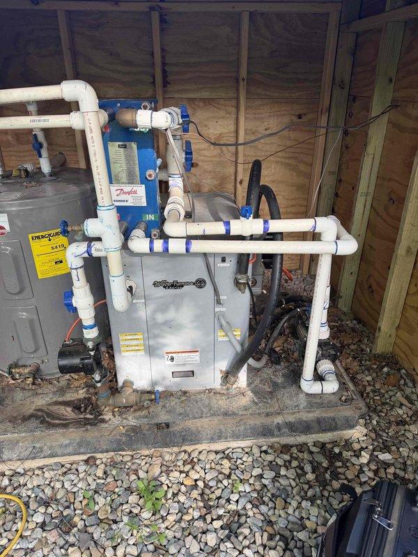 Responded to service call for non-operational geothermal heat pump located at pool area equipment pad. Upon arrival, performed diagnostic testing using Aurora AID diagnostic tool which indicated high pressure fault condition in the system. The geothermal unit, installed with Danfoss water filtration components and PVC piping configuration, showed fault status during testing mode. Documented existing equipment setup including electrical panel, water treatment system, and ground loop connections. Advised customer that repair work would be weather-dependent due to outdoor installation location and current conditions affecting safe service access.