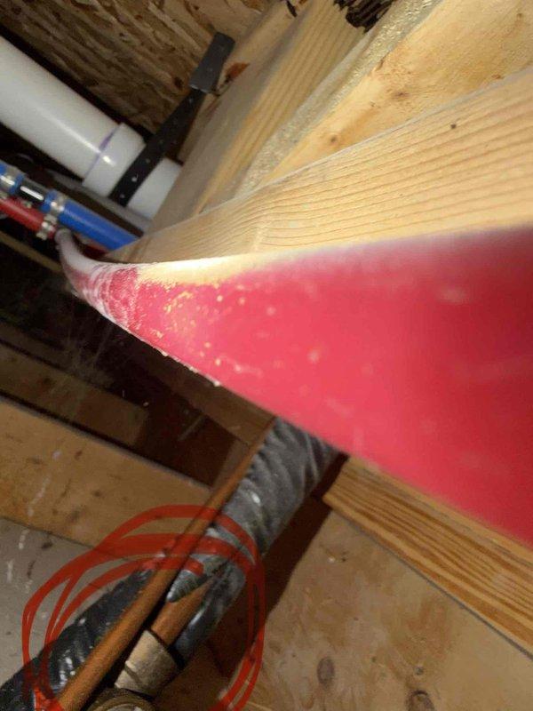 Responded to service call to investigate reported kink in refrigerant line set. Accessed mechanical area and attic space to inspect copper line routing and installation. Documented current conditions with photos showing line set path through utility closet and attic framing areas where spray foam insulation has been applied. Unable to locate specific kink during this visit. Return trip required with customer present to walk through and identify exact location of suspected restriction in line set.