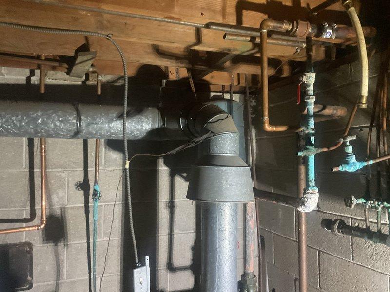 Conducted comprehensive assessment of residential HVAC system and existing water heater installation in basement mechanical room to provide replacement estimate. Evaluated current copper piping configuration, ductwork system with reflective insulation, and mechanical equipment mounted to concrete block walls and floor joists. Documented existing infrastructure including plumbing connections, gas lines, electrical conduit, and ventilation requirements to determine scope of replacement work and equipment specifications needed for complete system upgrade.