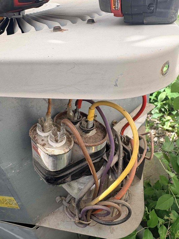 Responded to no cooling complaint with indoor temperature at 90 degrees. Upon inspection of outdoor condensing unit, identified failed dual run capacitor exhibiting visible corrosion and rust on casing. Removed defective capacitor and replaced with new component, restored all electrical connections, and verified system operation. Unit cooling properly upon departure.