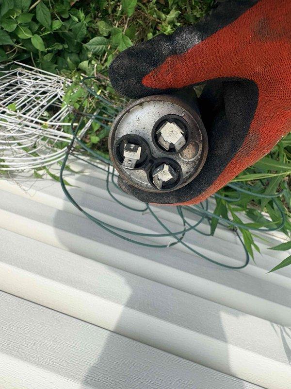 Responded to no cooling complaint with indoor temperature at 90 degrees. Upon inspection of outdoor condensing unit, identified failed dual run capacitor exhibiting visible corrosion and rust on casing. Removed defective capacitor and replaced with new component, restored all electrical connections, and verified system operation. Unit cooling properly upon departure.