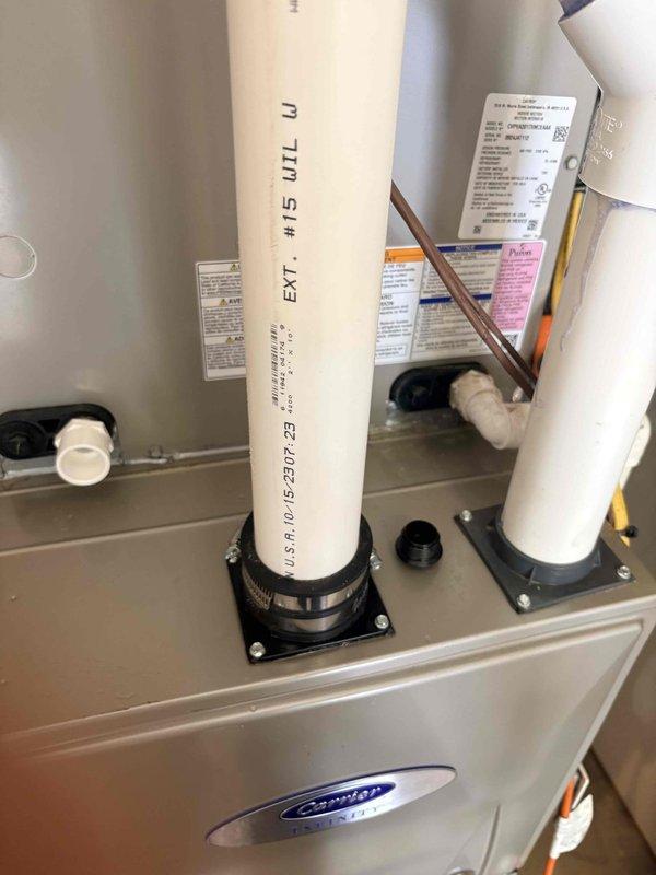 Responded to water leak concern on Carrier Infinity HVAC system. Relocated condensate drain line from incorrect port to proper drainage port on unit. Secured all PVC drain piping with appropriate mounting brackets and stainless steel clamps to ensure proper drainage pathway and prevent future condensate-related water leaks.