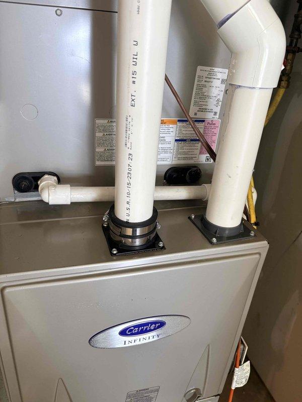 Responded to water leak concern on Carrier Infinity HVAC system. Relocated condensate drain line from incorrect port to proper drainage port on unit. Secured all PVC drain piping with appropriate mounting brackets and stainless steel clamps to ensure proper drainage pathway and prevent future condensate-related water leaks.
