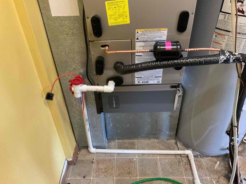 Completed full HVAC system installation including Carrier FE5BNXB24L00 furnace with 8KW heat kit, 27VNA324A003 air conditioning unit, and SYSTXCCITC01-C thermostat in utility closet. Reused existing refrigerant linesets after performing complete system flush to remove contaminants. Installed new 1210 media filter for improved air quality, new pad-mounted disconnect switch, and electrical whip for proper power connection. Mounted filter drier on refrigerant lines with service ports for future maintenance access. Installed condensate drain pan with PVC trap configuration and connected drain lines to prevent water damage. Verified all electrical connections, refrigerant line connections, and tested system operation. System is covered under 10-year parts warranty and 1-year labor warranty.