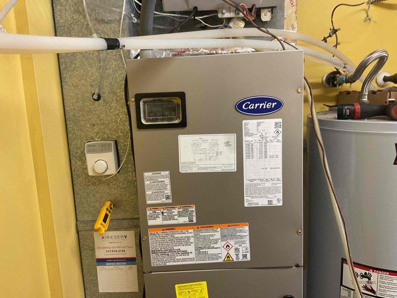 Completed full HVAC system installation including Carrier FE5BNXB24L00 furnace with 8KW heat kit, 27VNA324A003 air conditioning unit, and SYSTXCCITC01-C thermostat in utility closet. Reused existing refrigerant linesets after performing complete system flush to remove contaminants. Installed new 1210 media filter for improved air quality, new pad-mounted disconnect switch, and electrical whip for proper power connection. Mounted filter drier on refrigerant lines with service ports for future maintenance access. Installed condensate drain pan with PVC trap configuration and connected drain lines to prevent water damage. Verified all electrical connections, refrigerant line connections, and tested system operation. System is covered under 10-year parts warranty and 1-year labor warranty.