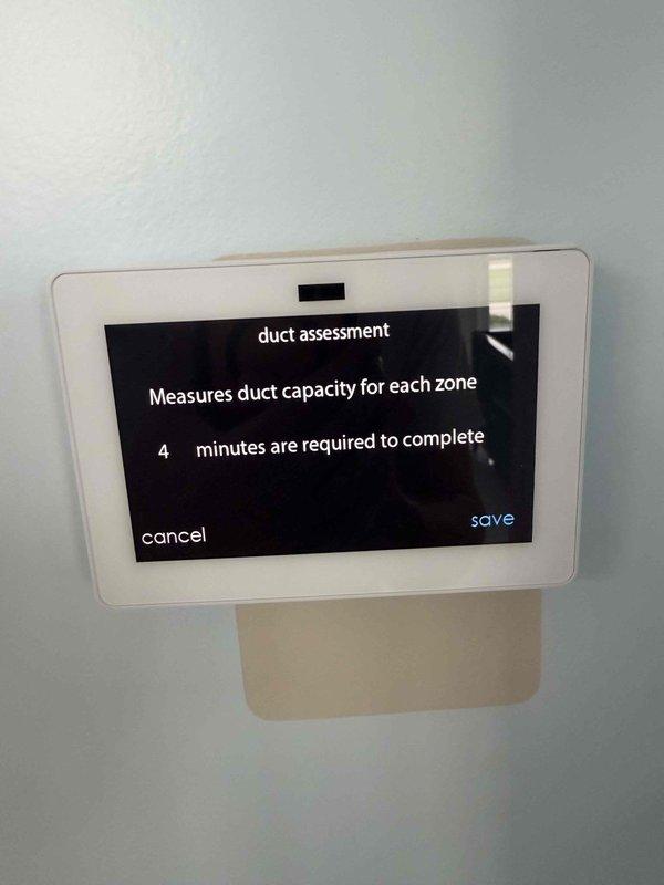Installed white programmable thermostat with touchscreen display and multi-zone capability as requested. Configured system settings for Zone 1 with heating and cooling setpoints, programmed auto mode operation, and verified proper communication with HVAC equipment. Initiated duct assessment function to measure duct capacity for zoned system operation.