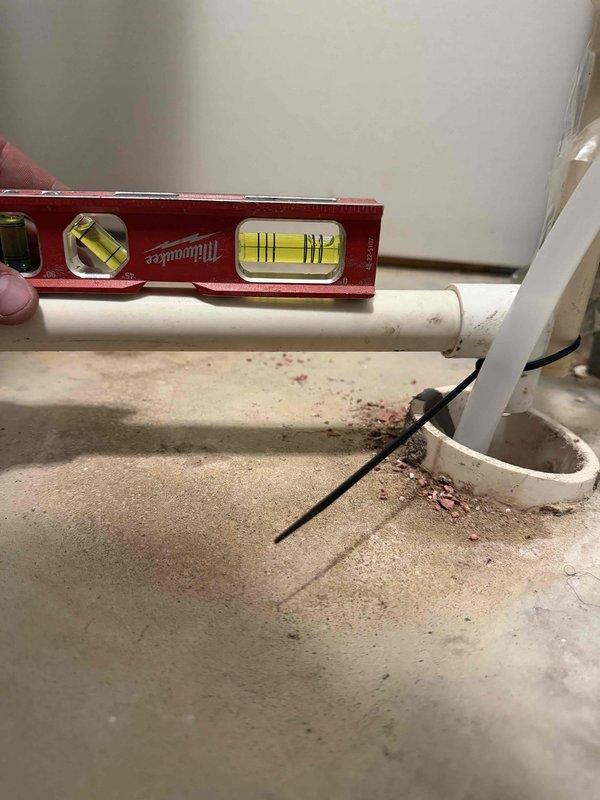 Responded to reported water softener leak on a repeat service call. Upon inspection, verified proper installation and leveling of PVC discharge piping using precision measuring equipment. Documented site conditions and plumbing configuration with photographic evidence to determine leak source and assess whether issue resulted from installation defect or external factors affecting the system.