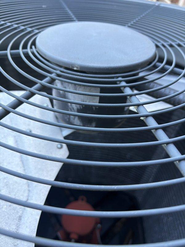 Completed routine maintenance inspection on residential cooling system. Performed visual assessment of outdoor condenser unit, confirmed fan assembly and protective grille in proper working condition, and conducted electrical diagnostics using clamp meter to verify amperage draw of 5.79 amps, indicating normal operating parameters for the compressor circuit.