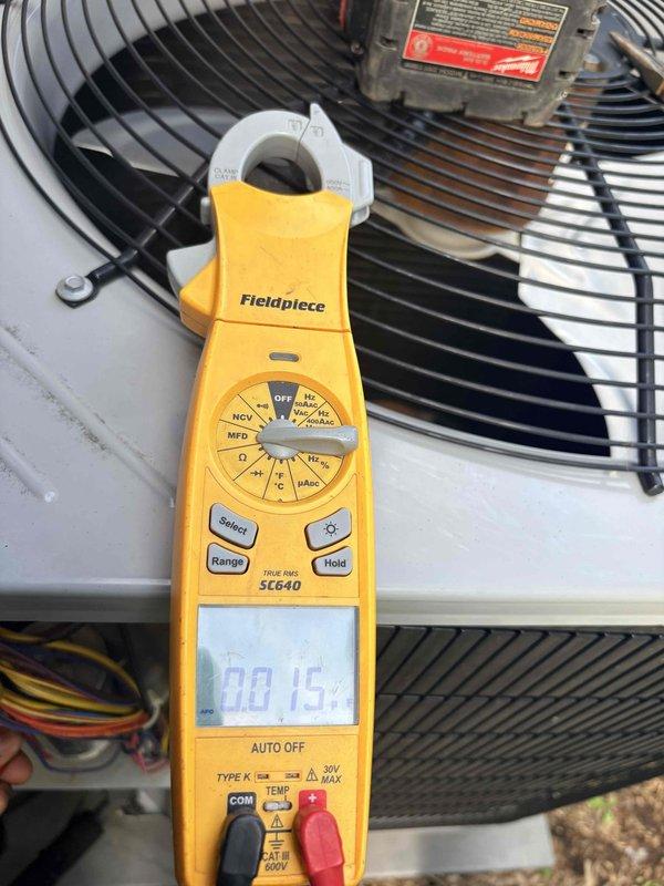 Responded to no cooling complaint with outdoor fan running but no cold air production. Performed diagnostic testing on condensing unit electrical components using clamp meter, measuring capacitor microfarad ratings at 0.15 MFD, indicating failed dual run capacitor well below manufacturer specifications. Replaced defective capacitor, verified proper compressor amperage draw, and confirmed system returned to normal cooling operation with appropriate temperature split across evaporator coil.
