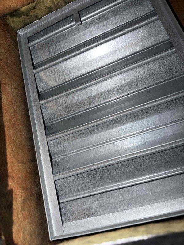 Completed scheduled monthly preventive maintenance on Lloyd Industries cooling system. Performed comprehensive inspection of air handler unit and return air grille, verifying proper airflow through horizontal louver assembly. Documented equipment condition with manufacturer identification plates visible and confirmed UL-listed components in serviceable condition. Cleaned accumulated dust from return grille slats and verified secure mounting within wooden framing structure. Inspected surrounding insulation for proper placement and checked ductwork panel for structural integrity. All components operating within normal parameters with no immediate service needs identified.