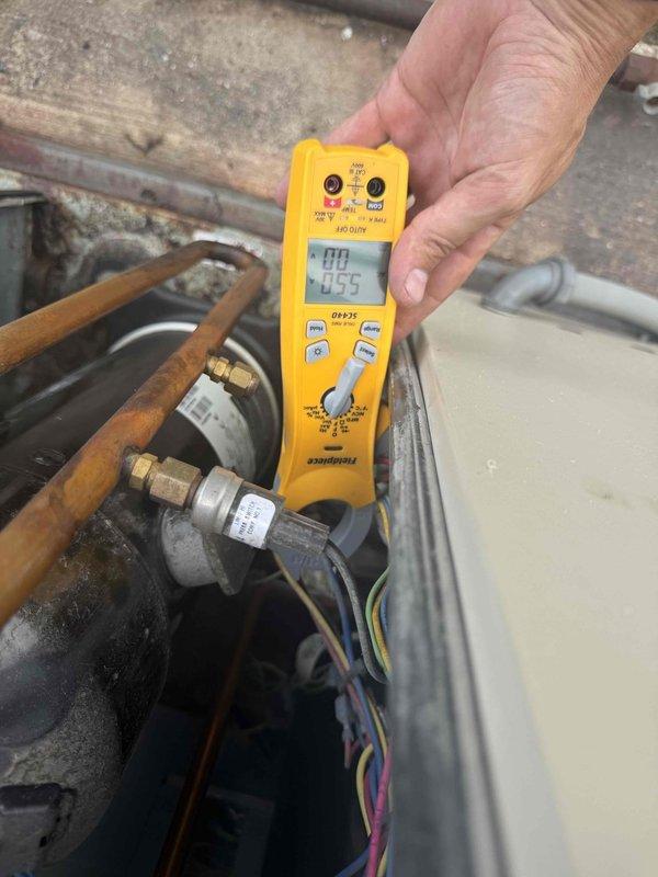 Responded to callback for inadequate cooling with indoor temperature reaching 83 degrees by afternoon. Upon inspection, found evaporator coil with moderate dust and debris accumulation affecting heat transfer efficiency. Took diagnostic measurements using digital multimeter, recording readings of system components and refrigerant pressures at outdoor condensing unit. Documented condition of copper refrigerant lines, brass fittings, and compressor connections showing normal wear and oxidation. Assessed airflow restriction caused by soiled coil surfaces and filter contamination, which was contributing to reduced cooling capacity and afternoon temperature rise.