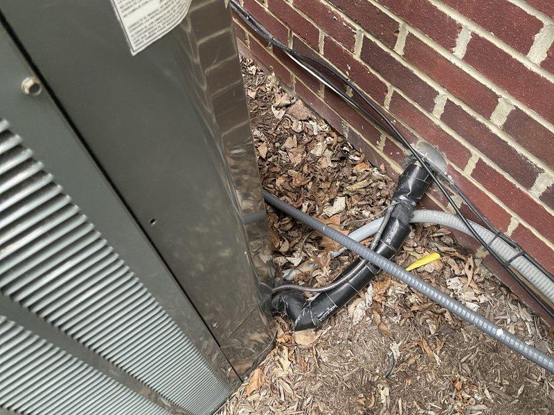 Conducted on-site evaluation of 16-year-old existing HVAC system for Carrier replacement estimate. Assessed outdoor condensing unit positioned against exterior brick wall and inspected indoor air handling components in utility area. Documented current equipment configuration, electrical conduit routing, refrigerant line placement, and existing system layout to provide comprehensive replacement proposal for complete system upgrade.