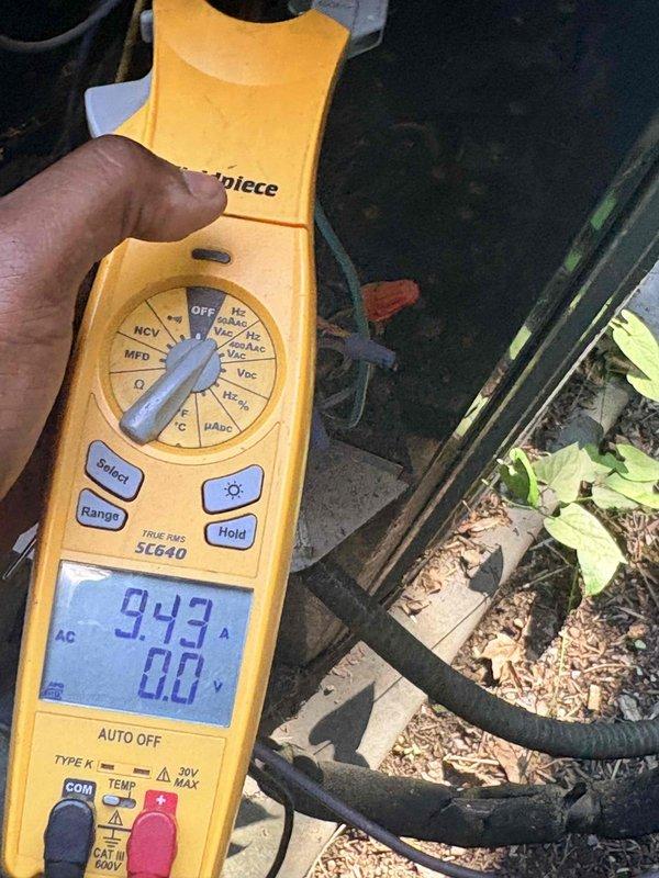 Completed scheduled cooling maintenance on residential air conditioning system. Performed comprehensive inspection of outdoor condensing unit, including visual assessment of capacitor which showed signs of age with corrosion present on electrical terminals and weathering on housing. Utilized Fieldpiece SC640 clamp meter to test capacitor performance, recording microfarad reading of 9.42. Inspected electrical connections, noting red and purple wires connected to capacitor terminals with visible oxidation typical of outdoor exposure. Evaluated overall unit condition, documenting accumulated dirt and grime on interior components and chassis. System operational at time of service completion.