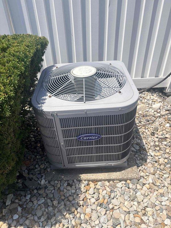 Completed comprehensive air conditioning tune-up on Carrier outdoor condensing unit. Performed electrical diagnostics using digital multimeter to verify capacitor function and electrical connections, inspected condenser coil and fan assembly, and confirmed proper system operation. Unit found in satisfactory condition with all components functioning within normal parameters.