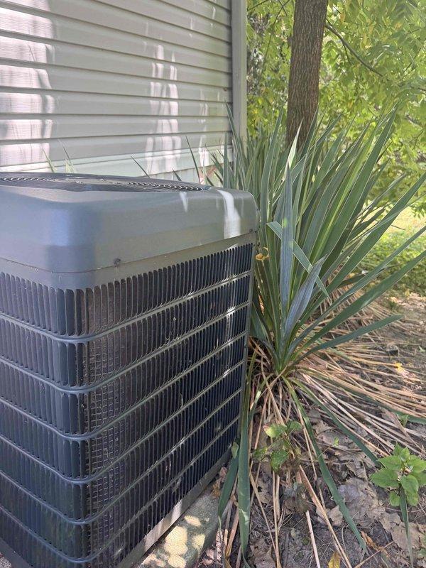 Responded to no cooling complaint on unit less than 10 years old that had been cycling intermittently with visible frost accumulation on evaporator coil. Upon inspection, found outdoor condenser coil heavily contaminated with dirt, dust, and debris buildup restricting airflow, which caused reduced system capacity and evaporator freezing. Documented condition of condenser unit showing significant maintenance neglect with substantial contamination between cooling fins and surrounding landscaping encroachment.