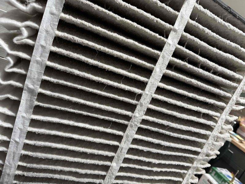 Completed monthly cooling maintenance on HVAC system, which included replacing heavily soiled air filter that showed significant dust and debris accumulation across all horizontal slats and frame elements. Inspected blower wheel assembly and noted dust buildup on squirrel cage fan blades and housing, though all mechanical components remain intact and functional.