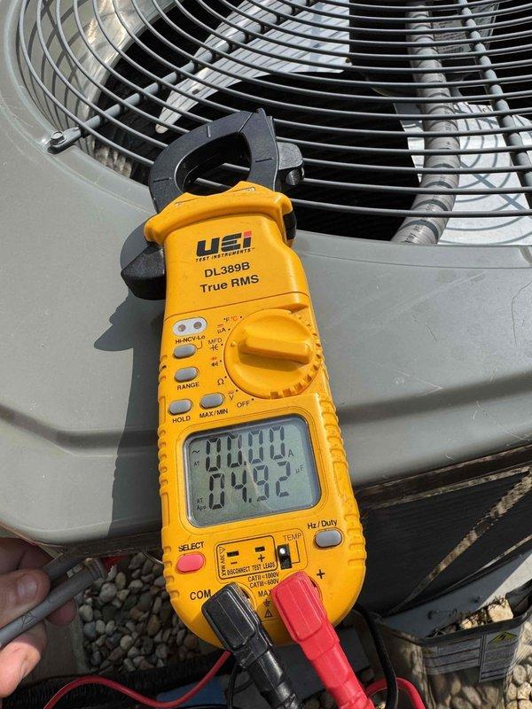 Completed comprehensive cooling system maintenance on outdoor condensing unit. Performed electrical diagnostics using digital clamp meter to verify proper amperage draw and system performance, with temperature readings indicating normal operating parameters at 4.2°F. Inspected refrigerant line set and evaporator coil assembly, noting copper tubing and aluminum fin condition with typical weathering consistent with system age but no significant deterioration or damage requiring immediate attention.