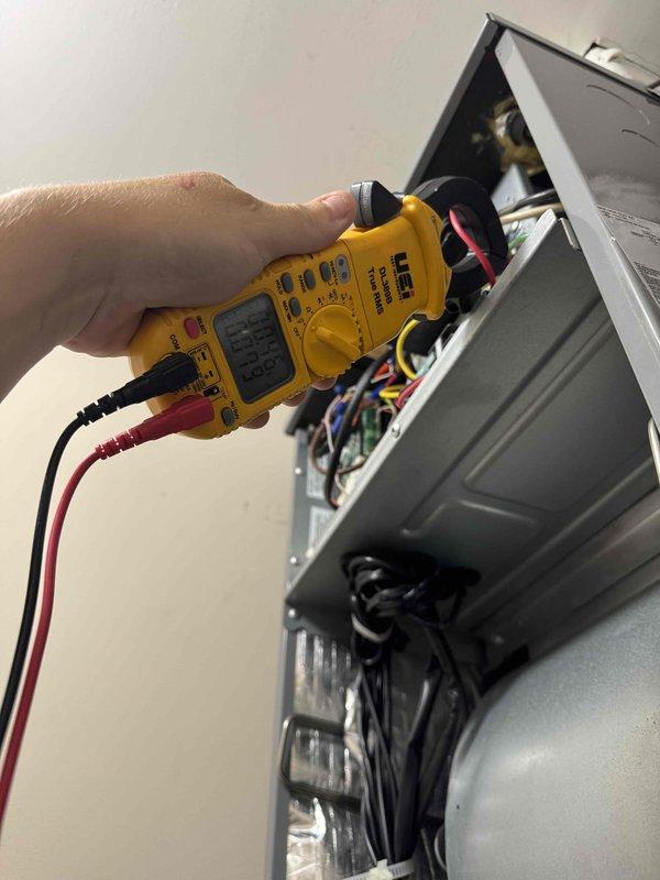Completed comprehensive Super Tune-Up service on residential HVAC system. Performed electrical diagnostics using digital multimeter to verify proper voltage and amperage at the air handler's wiring compartment, confirming all electrical connections were secure and within manufacturer specifications. Verified Carrier thermostat operation showing system maintaining 72°F setpoint with hold function active and 57% humidity level displayed; confirmed thermostat communication and control functions operating correctly.