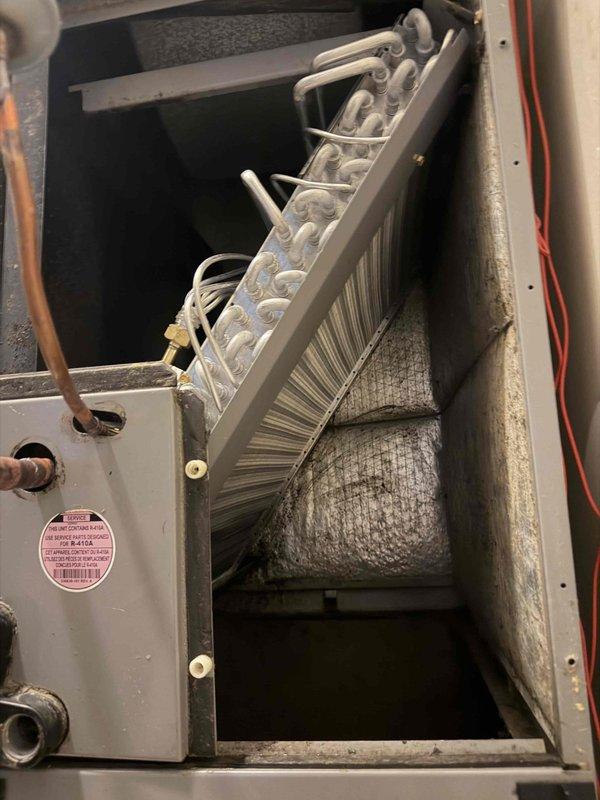 Replaced heavily soiled evaporator coil in heat pump system that exhibited significant dust and debris accumulation affecting system performance. Removed old coil unit from metal housing, disconnected refrigerant lines, and installed new evaporator coil with proper refrigerant connections and electrical terminations.