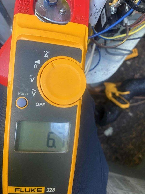 Performed scheduled cooling maintenance on HVAC system. Customer reported warm air discharge following recent installation. Conducted diagnostic testing using digital multimeter and clamp meter to measure voltage and amperage at system components. Readings indicated 569.5V AC and verified electrical parameters at equipment. Inspected electrical connections, capacitor, and motor components within unit cabinet. Documented measurements and system conditions with diagnostic equipment to assess cooling performance issue.