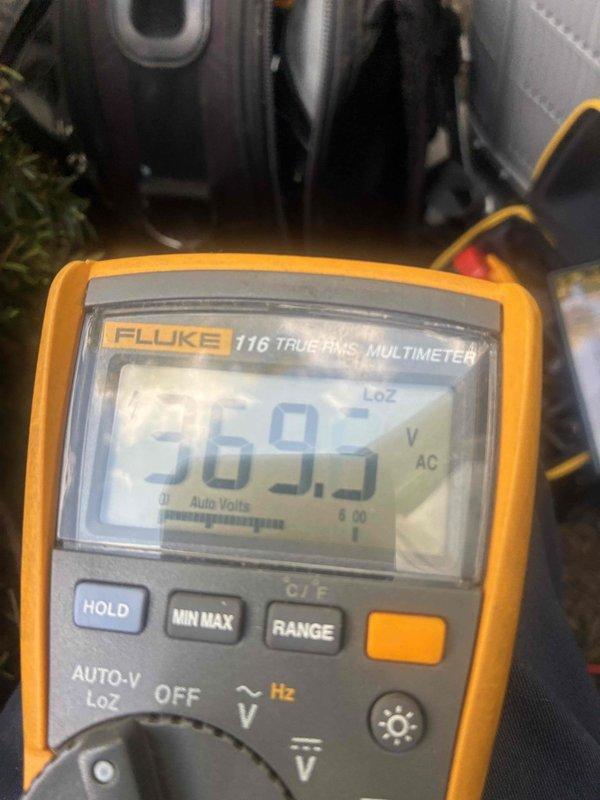 Performed scheduled cooling maintenance on HVAC system. Customer reported warm air discharge following recent installation. Conducted diagnostic testing using digital multimeter and clamp meter to measure voltage and amperage at system components. Readings indicated 569.5V AC and verified electrical parameters at equipment. Inspected electrical connections, capacitor, and motor components within unit cabinet. Documented measurements and system conditions with diagnostic equipment to assess cooling performance issue.