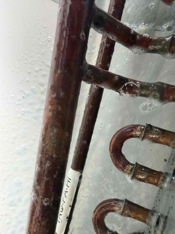 Responded to no-cooling call with frozen evaporator coil. Upon arrival, confirmed outdoor condenser unit operational with manifold gauge set showing abnormal pressure readings indicative of restricted airflow or low refrigerant charge. Inspection revealed severely corroded evaporator coil with significant oxidation, rust buildup, and mineral deposits throughout the serpentine tubing. The deteriorated condition of the coil was causing inadequate heat exchange and ice formation on refrigerant lines. Documented equipment condition with photos showing gauge readings and coil degradation. Recommended evaporator coil replacement due to extensive corrosion compromising system performance and efficiency.