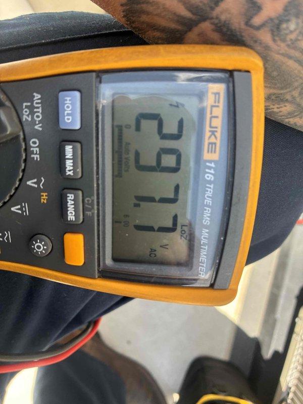 Completed scheduled cooling maintenance on rooftop AC unit at townhouse location, accessing equipment via rooftop patio. Performed comprehensive system diagnostics including electrical measurements, recording 29.77 VAC and 3.333 amp readings using calibrated multimeter to verify proper voltage supply and current draw. All electrical parameters were within normal operating specifications, and unit was found to be functioning properly upon completion of maintenance inspection.