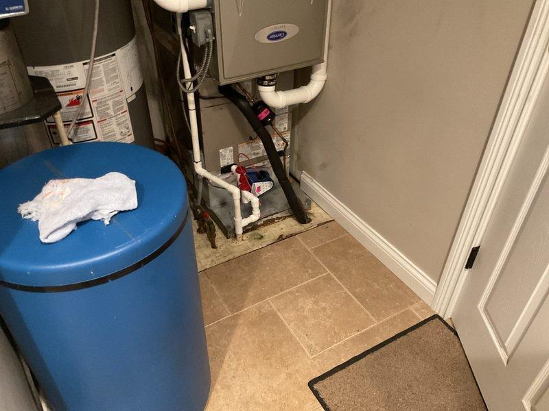 Returned to complete HVAC system installation in residential utility room. Finalized installation of Carrier furnace unit with complete PVC venting and ductwork connections, verified proper integration with existing water heater and pressure tank system. All equipment tested and operational, installation documented with photos showing completed mechanical room setup with proper clearances and code-compliant piping configurations.