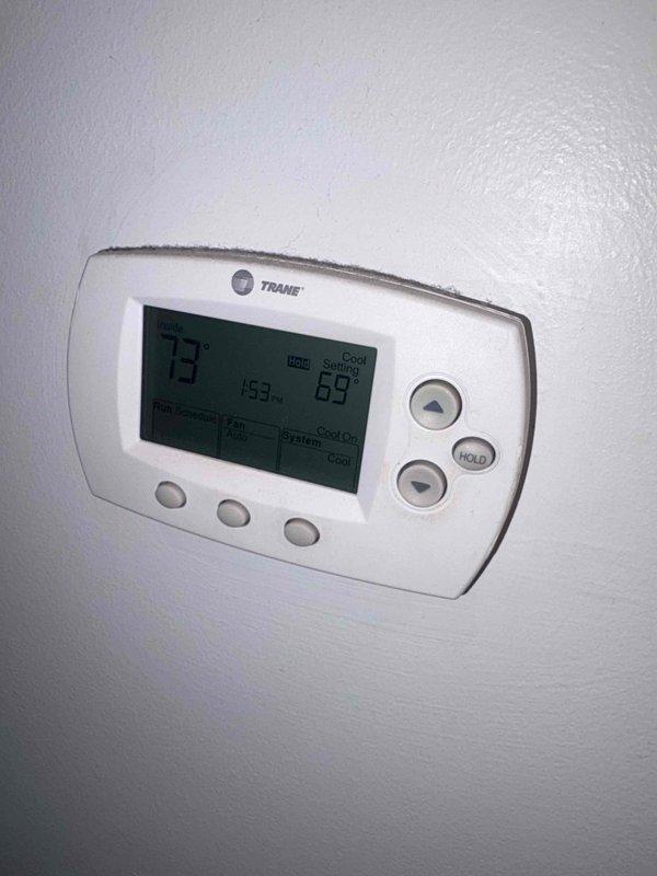 Completed scheduled cooling maintenance on Trane system. Performed comprehensive system diagnostics including electrical testing with digital multimeter, verified proper voltage readings at components, and inspected condenser unit operation. Confirmed thermostat functionality with display showing accurate temperature reading of 73°F and cooling setpoint of 69°F in active cooling mode. All electrical connections tested secure, refrigerant pressures within manufacturer specifications, and system operating efficiently with no deficiencies noted.