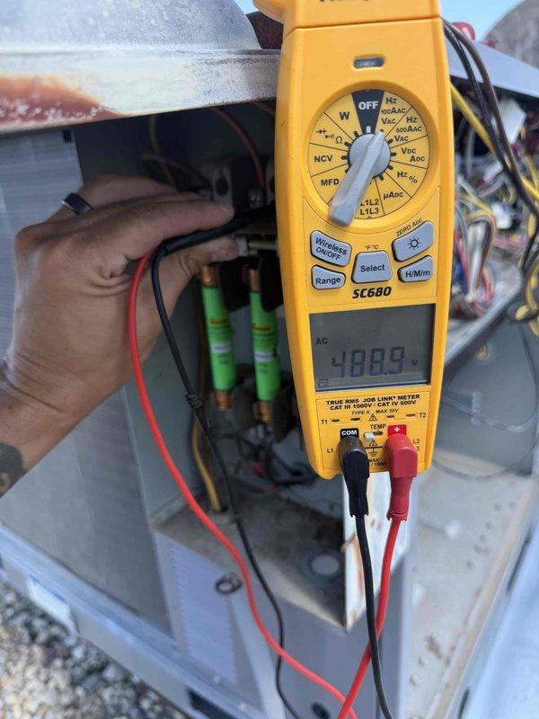 # HVAC No Heat Service Call - Second Opinion Evaluation

Responded to service request for second opinion on previously quoted repairs including condenser fan motor, condenser fan blade, and blower motor replacement. Upon arrival, performed comprehensive diagnostic evaluation of heating system.

## Diagnostic Procedures Performed

Conducted thorough electrical testing of HVAC system components using digital multimeter. Measured voltage readings at control board and capacitor bank, documenting readings of 480V at electrical panel. Inspected internal wiring harness and terminal connections at control board, verifying proper wire routing and connection integrity across all zones including reheat/heat pump circuits, phase connections, and remote terminals.

Examined control board circuitry and terminal blocks for signs of electrical failure, overheating, or component degradation. Verified all wire connections at AUX1, AUX2, occupancy, and exhaust control points were secure and properly term