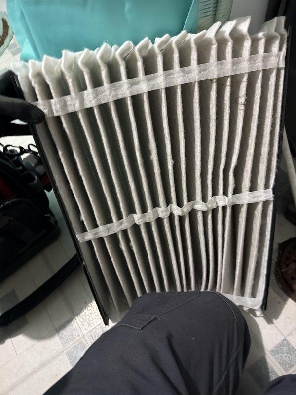 Performed scheduled cooling maintenance on HVAC system. Inspected and evaluated air filtration components, noting moderate dust accumulation on pleated filter media. Documented filter condition through photography, showing visible particulate buildup across accordion-style pleats indicating normal operational wear. Filter housing and surrounding system components were examined for proper fit and seal integrity. System is due for membership renewal consideration.