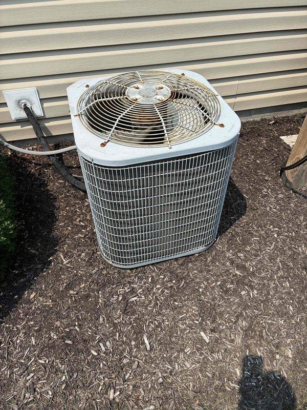 Responded to no cooling complaint on residential air conditioning system. Upon arrival, evaluated aging outdoor condenser unit with cylindrical design and metal grille construction showing signs of deterioration and outdoor exposure. System was running but failing to provide adequate cooling due to age and condition of equipment exceeding 10 years of service life. Provided comprehensive full system replacement estimate covering new HVAC equipment installation to restore proper cooling functionality to the residence.