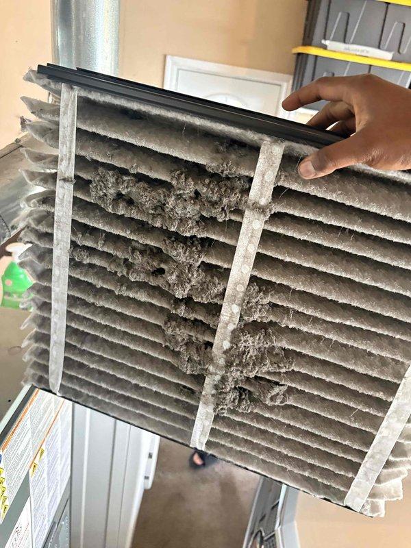 Completed scheduled cooling maintenance on residential HVAC system. Inspected outdoor condenser unit, confirmed proper fan operation and verified unit cleanliness with intact protective wire guard. Documented heavily soiled air filter with significant dust and debris accumulation, including dense particulate buildup restricting airflow, and recommended immediate replacement to restore proper system efficiency and indoor air quality.