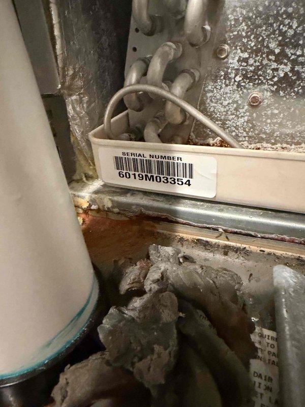 Responded to service call for HVAC unit with reported small leak and suspected condensate drain line backup. Upon inspection, found standing water with rust-colored discoloration in drain pan, indicating drainage system failure. Evidence suggested improper installation methods may have been used on original drain line. Removed existing condensate drain line and installed new PVC drain line with properly configured P-trap to ensure adequate air gap and prevent future backups. Tested drainage system operation and confirmed proper flow and function. Unit drain pan cleared of standing water and system returned to normal operation.