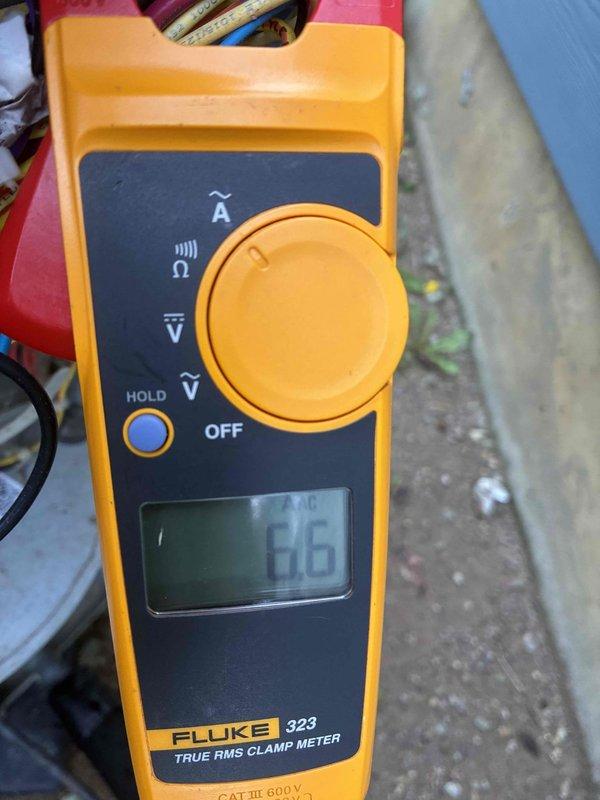 Completed scheduled cooling system maintenance visit on outdoor HVAC condenser unit. Performed standard diagnostic testing including voltage measurements at 97.8V AC using digital multimeter and amperage readings at 6.6A using clamp meter on refrigerant lines. Unit operational with all electrical parameters within normal operating range.