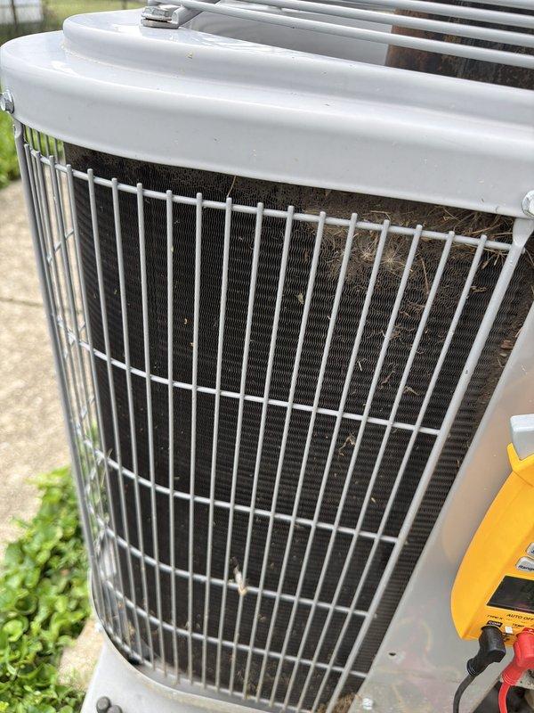 Completed scheduled cooling maintenance on outdoor condensing unit. Inspected condenser coil and protective grille, noting accumulated dirt and debris on filter material requiring cleaning. Performed electrical diagnostics using clamp meter to verify proper amperage draw and system operation. Installed new AprilAire #110 filter as part of routine maintenance to ensure optimal airflow and system efficiency.