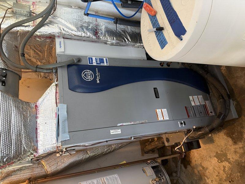 Responded to service call for non-operational geothermal system installed one year prior with recent maintenance history. Performed diagnostic evaluation of air handler unit and associated ductwork in mechanical space, taking temperature differential readings across the system which indicated 13.5°F and 6.7°F measurements. Inspected geothermal heat pump components, refrigerant lines, condensate drainage system, electrical connections, and ductwork integrity to identify cause of system failure and restore proper heating and cooling operation.