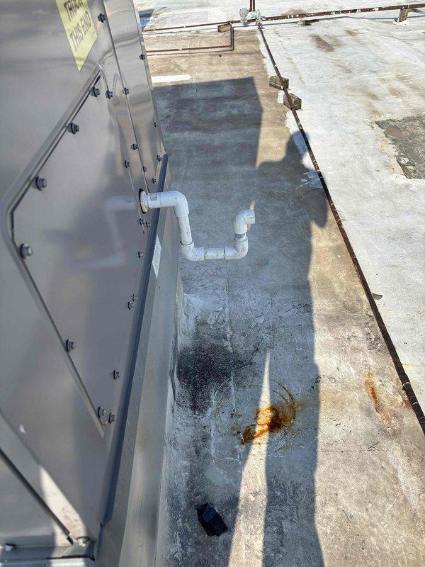 Responded to commercial no-cool call for three rooftop units experiencing operational failure and excessive condensation issues. Inspected rooftop HVAC equipment and identified problems with condensate drain system, evidenced by visible PVC trap configuration and water staining on concrete pad beneath units. Evaluated ceiling diffusers and flexible ductwork connections to assess airflow issues related to non-operational units.