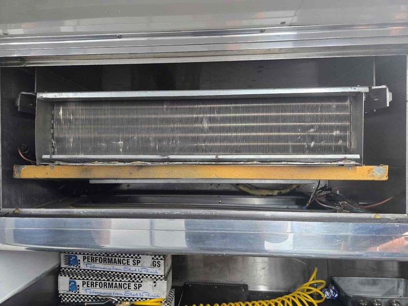 Responded to service call for three non-operational mini split systems installed in a racing trailer. Performed diagnostic inspection of all units, accessing evaporator coils and examining condenser components including compressors, refrigerant lines, and accumulator tanks. Documented equipment condition through photographic evidence showing internal coil assemblies, copper line sets with insulation, and outdoor condenser units with visible weathering and dirt accumulation on surfaces.
