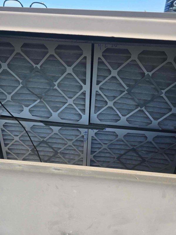 Performed diagnostic inspection of HVAC system and identified cracked fan belt requiring immediate replacement to prevent system failure. Documented existing conditions including belt-driven pulley assembly showing normal wear and operational air filter array in housing. Repair was approved and scheduled for completion during designated service window to restore unit to full operational capacity.